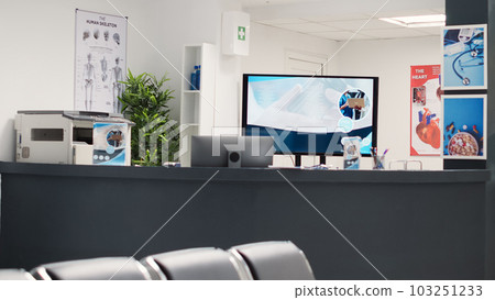 Empty chairs in hospital reception lobby, medical leaflets and forms on table to use before health care appointments. Waiting area seats in diagnostic center, clinical service. 103251233