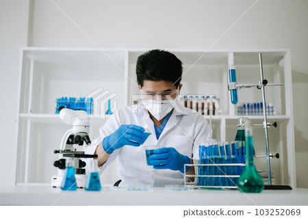 Male biotechnologist testing new chemical substances in a laboratory. 103252069