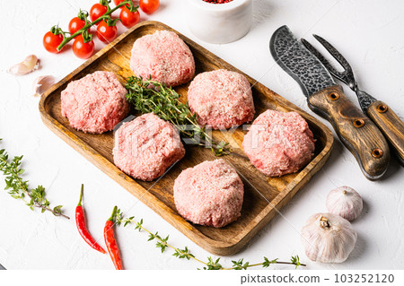 Raw chicken cutlets, ground meat patty, on white stone table background 103252120