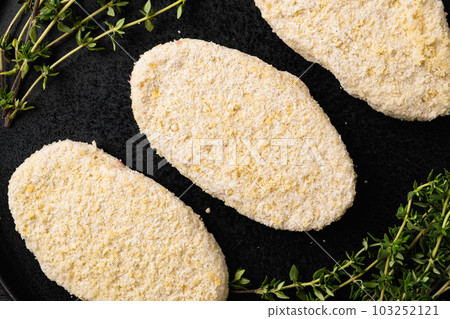 Fish burgers with crumbs, on black wooden table background, top view flat lay Fish burgers with crumbs, on black wooden table background, top view flat lay 103252121
