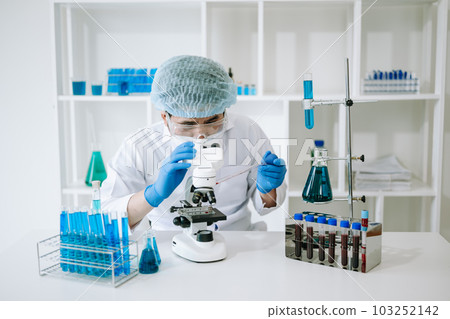 Male scientist researcher conducting an experiment in laboratory.. 103252142