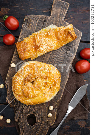 Burekas filled with cheese painir , on old dark wooden table background, top view flat lay Burekas filled with cheese painir , on old dark wooden table background, top view flat lay 103252751
