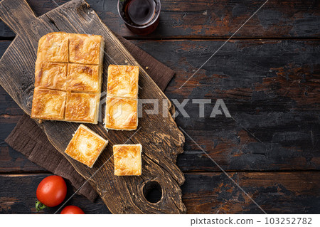 Su Boregi pie, Turkish Tabla borek or burek, on old dark  wooden table background, top view flat lay, with copy space for text 103252782