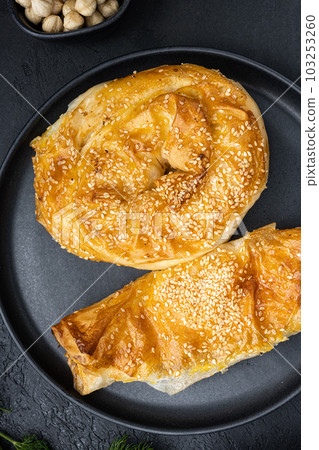 Turkish pastry filled with cheese, on black dark stone table background, top view flat lay Turkish pastry filled with cheese, on black dark stone table background, top view flat lay 103253260