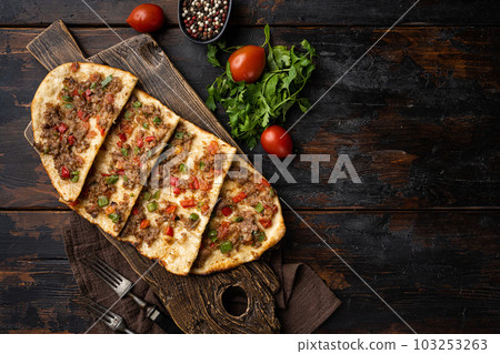 Pide with minced meat Turkish Kiymali Pide, on old dark wooden table background, top view flat lay, with copy space for text Pide with minced meat Turkish Kiymali Pide, on old dark wooden table background, top view flat lay, with copy space for text 103253263
