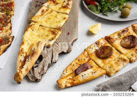 Assorted Kasarli Kiymali sucuklu  pide Turkish dish, on gray concrete table background, on gray concrete table background 103253264