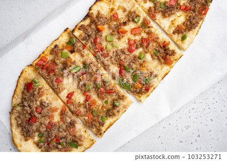 Pide Turkish dish with slices of beef, tomatoes, on gray concrete table background, top view flat lay 103253271