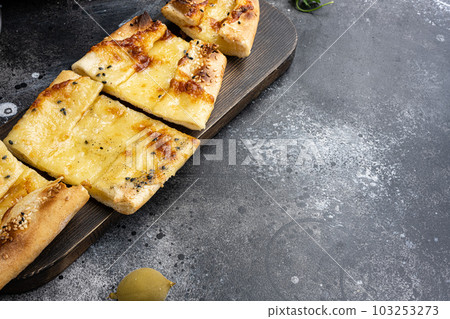 Pita with sujuk and kashar cheese, on black dark stone table background, with copy space for text 103253273