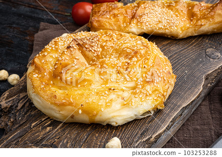 Turkish pastry filled with cheese, on old dark wooden table background Turkish pastry filled with cheese, on old dark wooden table background 103253288