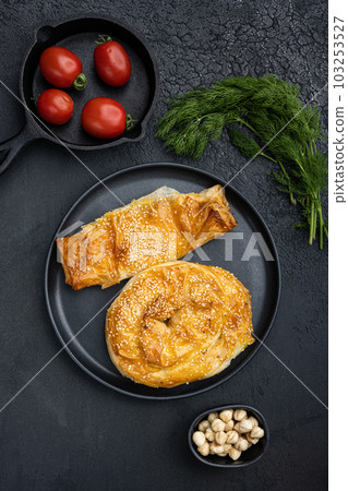 Burekas filled with cheese painir , on black dark stone table background, top view flat lay 103253527