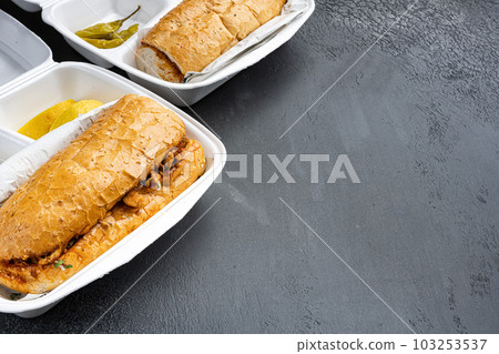 Chicken tantuni with loaf bread Turkish kebab, in plastic pack container delivery lunch box, on black dark stone table background, with copy space for text 103253537