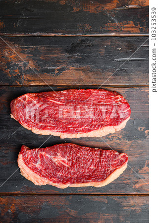 Pair of organic picanha beef meat steaks, over dark old wooden background, top view with space for text. 103253539