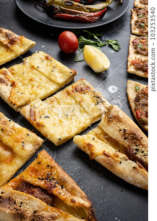 Pide, Cheddar cheese pita, traditional turkish pizza, on black dark stone table background 103253540