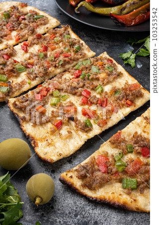 Kiymali pide Turkish pide with minced meat, on black dark stone table background 103253542