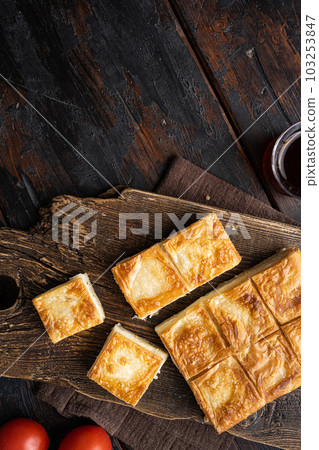 Delicious Turkish food Tray pastry with cheese, on old dark wooden table background, top view flat lay, with copy space for text Delicious Turkish food Tray pastry with cheese, on old dark wooden table background, top view flat lay, with copy space for text 103253847