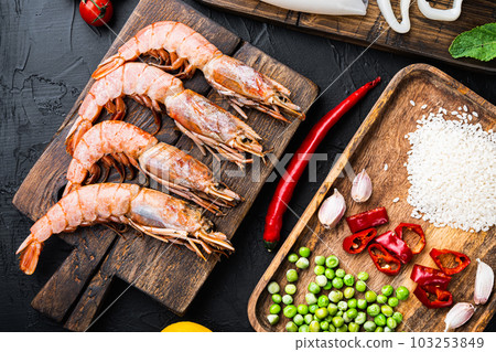 Traditional valenciana paella seafood ingredients with prawns, mussels, rice and spices on black concrete surface, flat lay Traditional valenciana paella seafood ingredients with prawns, mussels, rice and spices on black concrete surface, flat lay 103253849