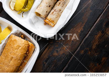 Somun ekmek tavuk tantuni Chicken Turkish doner kebab durum, on old dark wooden table background, top view flat lay, with copy space for text Somun ekmek tavuk tantuni Chicken Turkish doner kebab durum, on old dark wooden table background, top view flat lay, with copy space for text 103253857