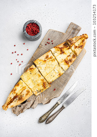 Turkish pide dish with tomatoes and salted cheese, on gray concrete table background, top view flat lay 103254173