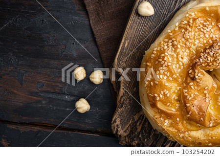Burekas filled with cheese painir , on old dark wooden table background, top view flat lay, with copy space for text Burekas filled with cheese painir , on old dark wooden table background, top view flat lay, with copy space for text 103254202
