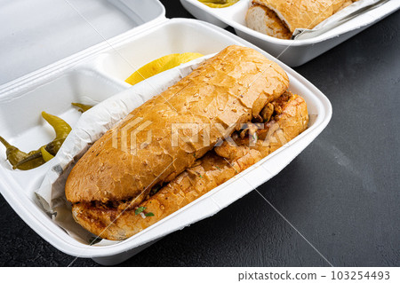 Tantuni doner kebab Somun ekmek tavuk, in plastic pack container delivery lunch box, on black dark stone table background, with copy space for text 103254493