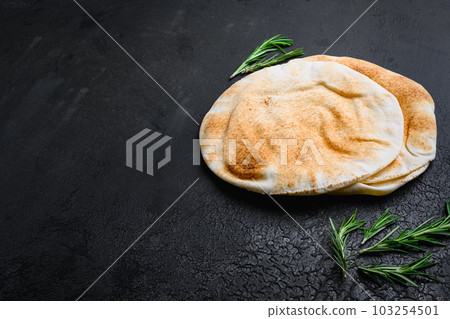 Pita flat bread set, on black dark stone table background, with copy space for text Pita flat bread set, on black dark stone table background, with copy space for text 103254501