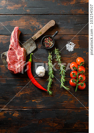 Fresh Dallas steak cut on meat cleaver. Organic farm marbled prime black angus beef. Dark wooden background. Top view. With seasonings, peppercorns, chilie, rosemary,salt,garlic. Copy space. . Fresh Dallas steak cut on meat cleaver. Organic farm marbled prime black angus beef. Dark wooden background. Top view. With seasonings, peppercorns, chilie, rosemary,salt,garlic. Copy space. . 103254507