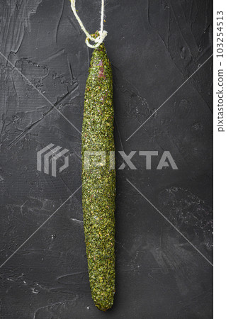Dry spanish sausage fuet in herbs on black background, topview Dry spanish sausage fuet in herbs on black background, topview 103254513