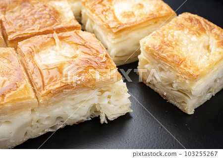 Turkish Su Boregi Burek with paynir, on black dark stone table background Turkish Su Boregi Burek with paynir, on black dark stone table background 103255267