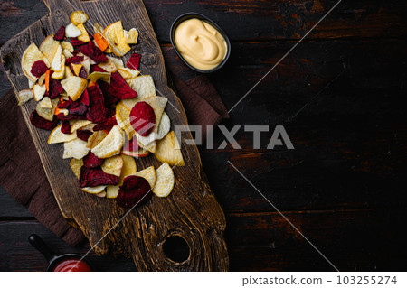 Root Vegetable Crisps, on black wooden table background, top view flat lay, with copy space for text 103255274