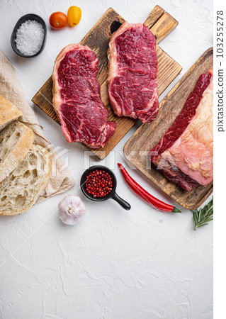 Strip loin steak, raw marbled meat, on white background, top view, with copy space for text Strip loin steak, raw marbled meat, on white background, top view, with copy space for text 103255278