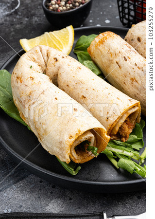Traditional Turkish cuisine doner kebab, on black dark stone table background Traditional Turkish cuisine doner kebab, on black dark stone table background 103255279