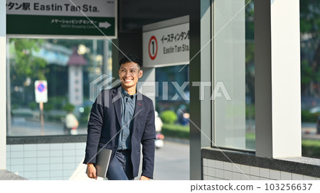 Smiling millennial man in business suit walking in subway station during his morning commute Smiling millennial man in business suit walking in subway station during his morning commute 103256637