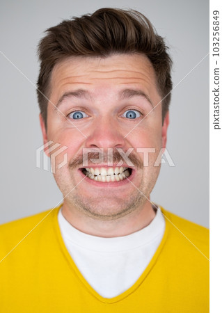 Caucasian crazy man with fake smile on face. Caucasian crazy man with fake smile on face. 103256849