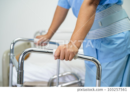 Asian lady patient use walker in hospital to support walking. Asian lady patient use walker in hospital to support walking. 103257561