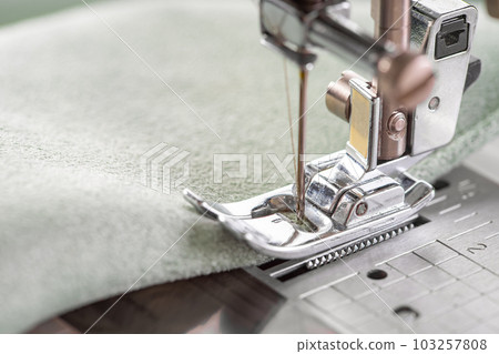 Modern sewing machine presser foot with green fabric and thread, closeup, macro Modern sewing machine presser foot with green fabric and thread, closeup, macro 103257808