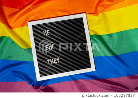 HE SHE THEY text Neo pronouns concept on Rainbow flag background gender pronouns. Non-binary people rights transgenders. Lgbtq community support assume my gender tolerance equal rights 103257837