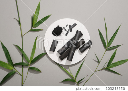 Organic activated charcoal put on white podium in round-shaped. Cosmetic product extracted from activated bamboo charcoal can treat acne 103258350