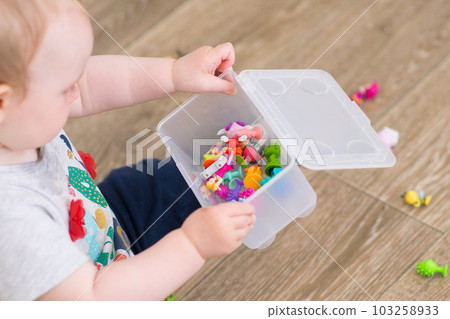 a small child plays with a constructor. cute girl and toys. High quality photo 103258933