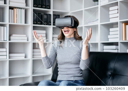 Businesswoman with vr headset lifestyle concept, Businesswoman wearing VR headset to playing game and touching experience virtual reality while relaxation with technology after working 103260409