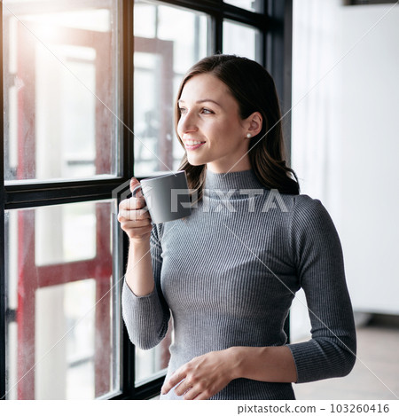 Businesswoman cozy lifestyle concept, Businesswoman drinking hot chocolate and standing near window to looking outside for take a break with enjoying while relaxation after working Businesswoman cozy lifestyle concept, Businesswoman drinking hot chocolate and standing near window to looking outside for take a break with enjoying while relaxation after working 103260416