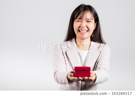 Smiling woman confidence holding red gift box on hands palm isolated white background, surprise birthday or Christmas day and valentine, Asian happy portrait beautiful female studio shot, copy space Smiling woman confidence holding red gift box on hands palm isolated white background, surprise birthday or Christmas day and valentine, Asian happy portrait beautiful female studio shot, copy space 103266517