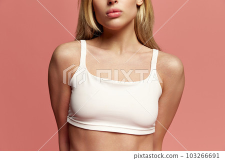 Cropped image of female body, breast in white underwear against pink studio background. Mammoplasty. Health. Plastic surgery 103266691