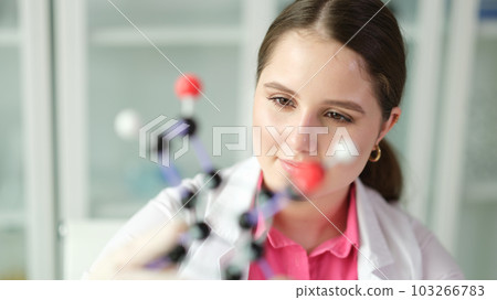 Woman scientist chemist studying molecule structure on plastic 3d model 103266783