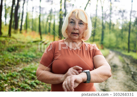 Active sport senior woman checking heart rate after run. Fitness healthy lifestyle concept. 103268331