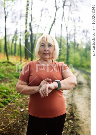 Active sport senior woman checking heart rate after run. Fitness healthy lifestyle concept. Active sport senior woman checking heart rate after run. Fitness healthy lifestyle concept. 103268343