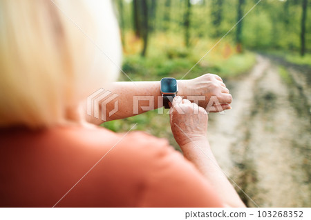 Active sport senior woman checking heart rate after run. Fitness healthy lifestyle concept. Active sport senior woman checking heart rate after run. Fitness healthy lifestyle concept. 103268352