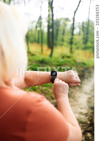 Active sport senior woman checking heart rate after run. Fitness healthy lifestyle concept. Active sport senior woman checking heart rate after run. Fitness healthy lifestyle concept. 103268353