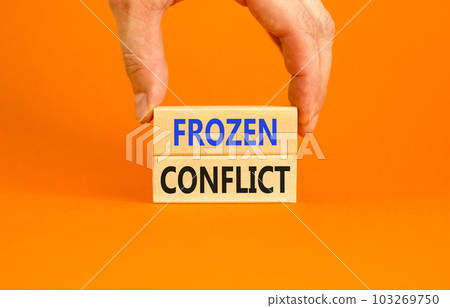 Frozen conflict symbol. Concept words Frozen conflict on beautiful wooden block. Beautiful orange table orange background. Businessman hand. Business and Frozen conflict concept. Copy space. 103269750