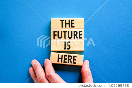 The future is here symbol. Concept words The future is here on wooden block. Beautiful blue table blue background. Businessman hand. Motivational business the future is here concept. Copy space. 103269788