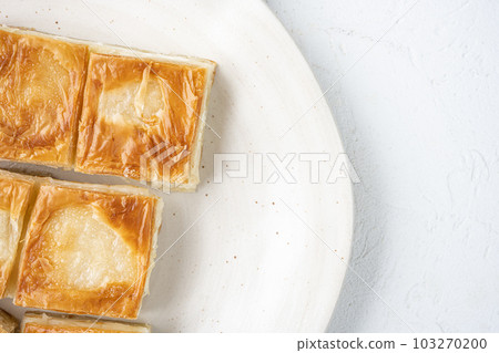 Turkish Pastry for Breakfast Su Boregi, on white stone table background, top view flat lay, with copy space for text 103270200